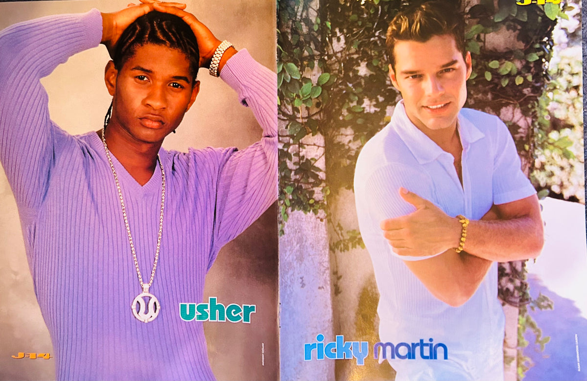 J-14 magazine double-sided poster side B split featuring Usher on left in purple ribbed top with diamond U pendant chain usher in teal font, and Ricky Martin on right in light blue polo shirt arms crossed with gold bracelet ricky martin in blue font, J-14 logos both sides, garden background