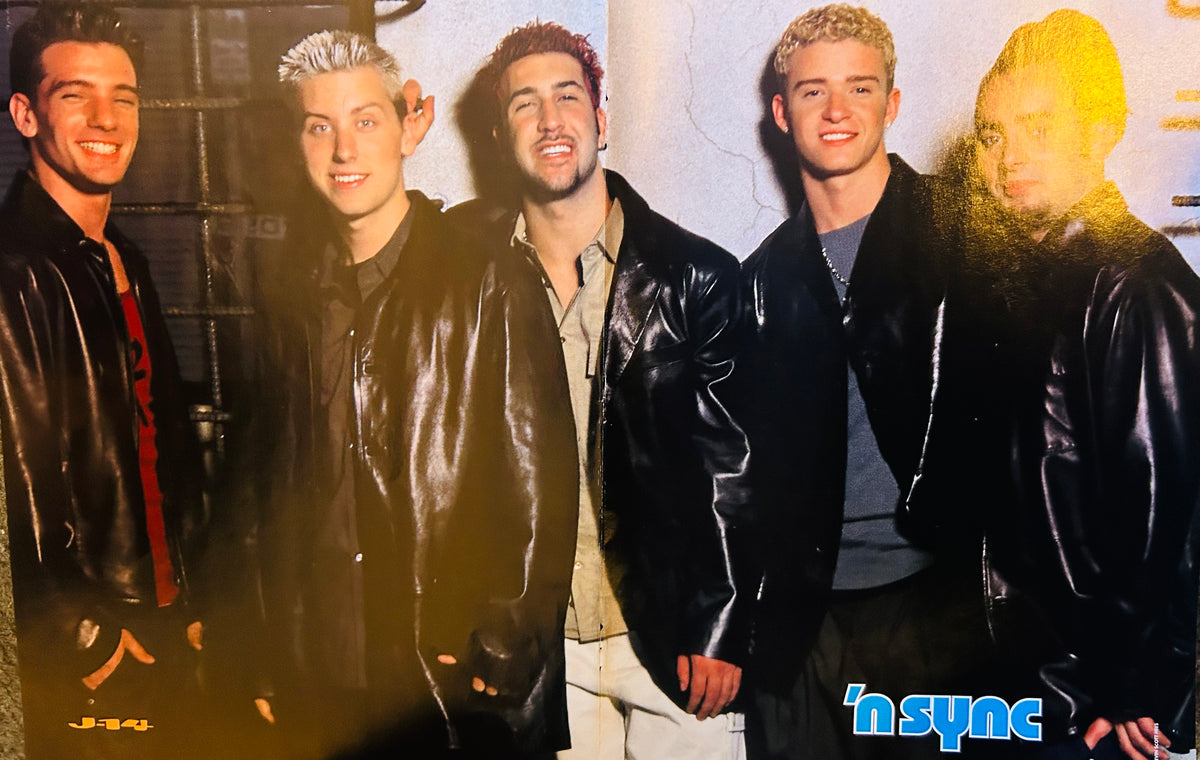 J-14 magazine double-sided poster side B featuring all five NSYNC members JC Chasez Lance Bass Joey Fatone Justin Timberlake and Chris Kirkpatrick in black leather jackets smiling in front of textured wall, n sync in bold blue font bottom right, J-14 logo bottom left