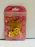 Pair of yellow round cheese charm drop earrings with hole details on silver fish hook wires, sealed in holographic pink zip bag with New Fashion cat display card
