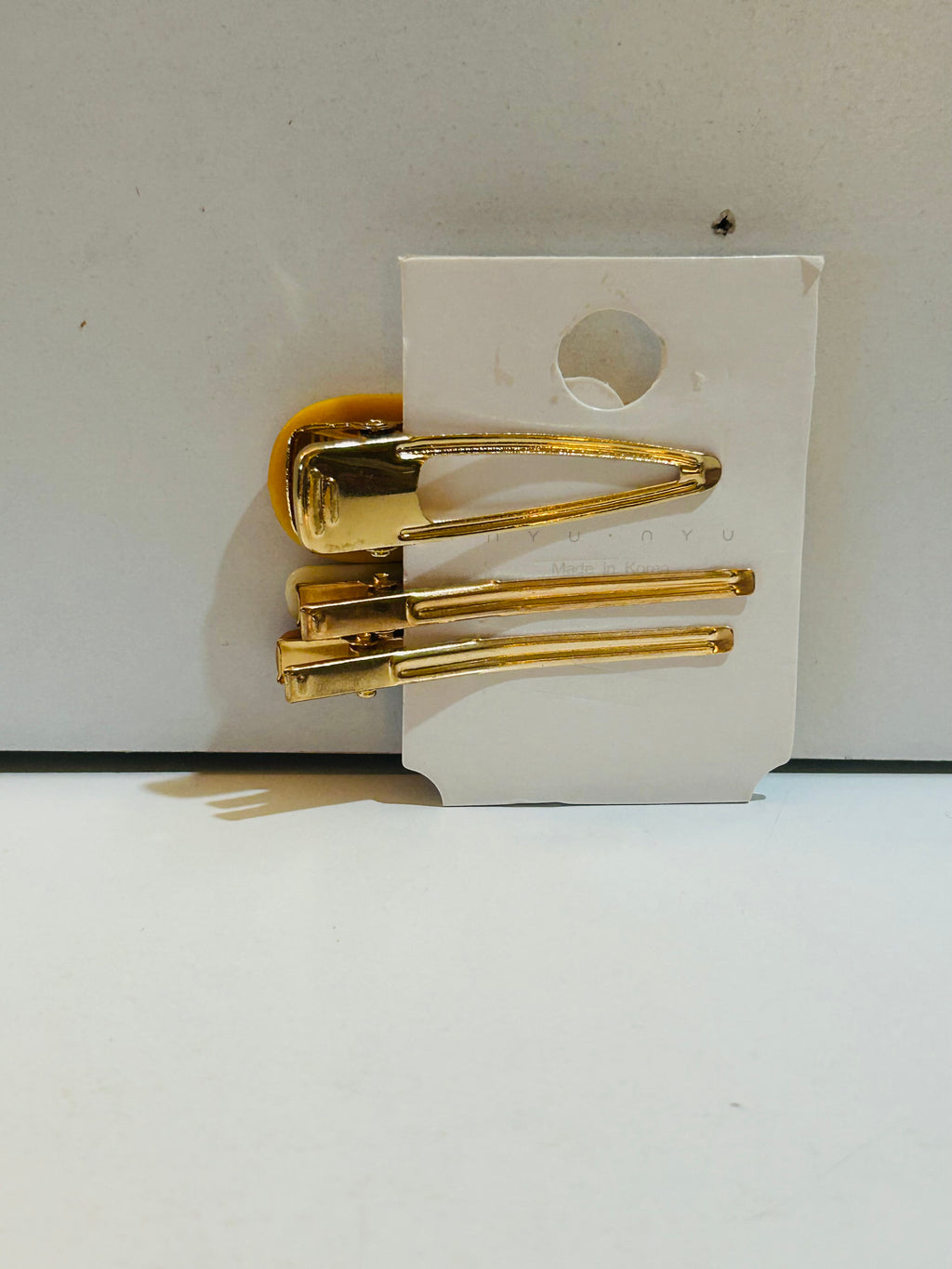 Set of 3 gold-tone hair barrettes on display card: one large snap barrette and two smaller slide pin barrettes