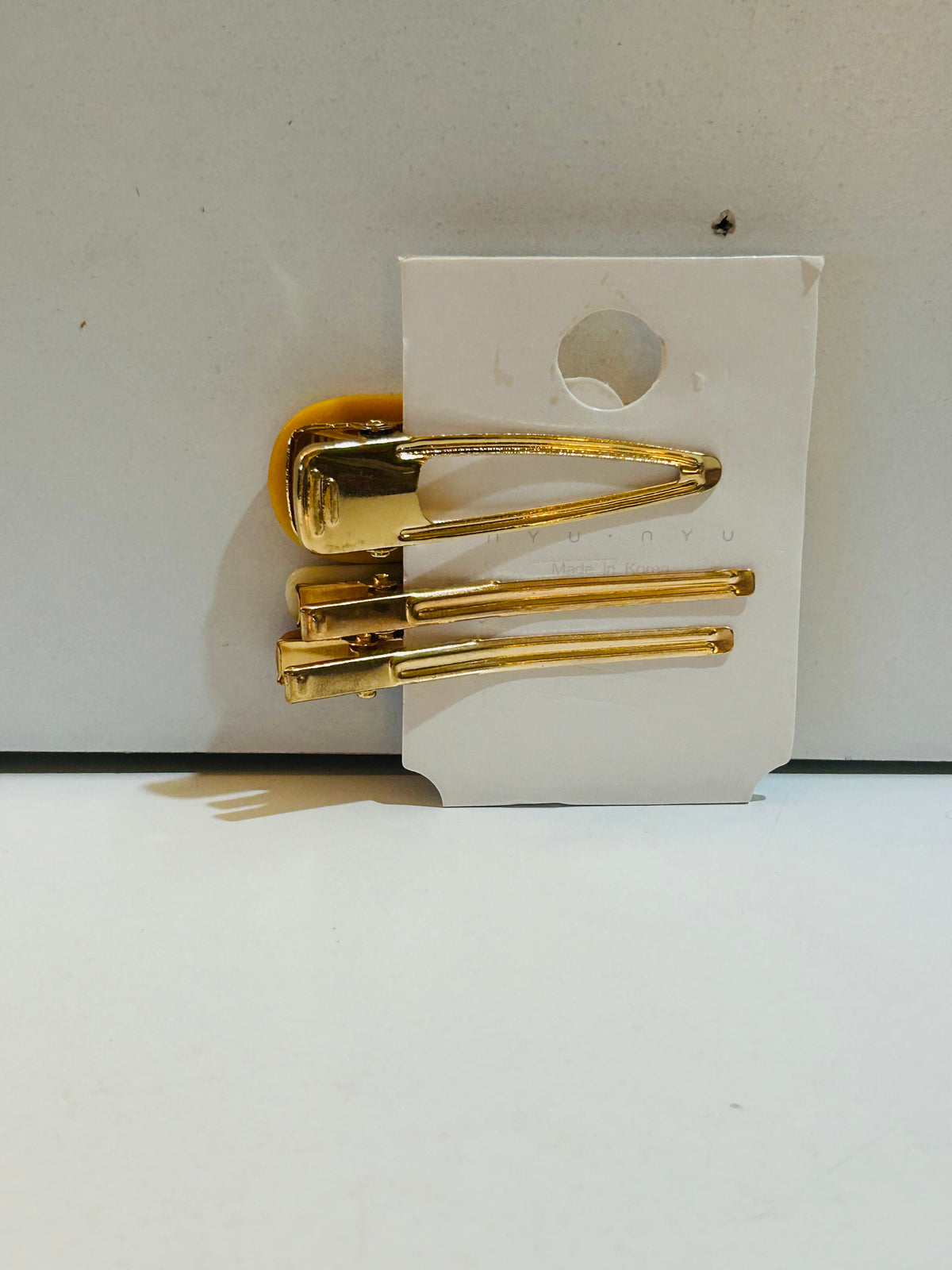 Set of 3 gold-tone hair barrettes on display card: one large snap barrette and two smaller slide pin barrettes