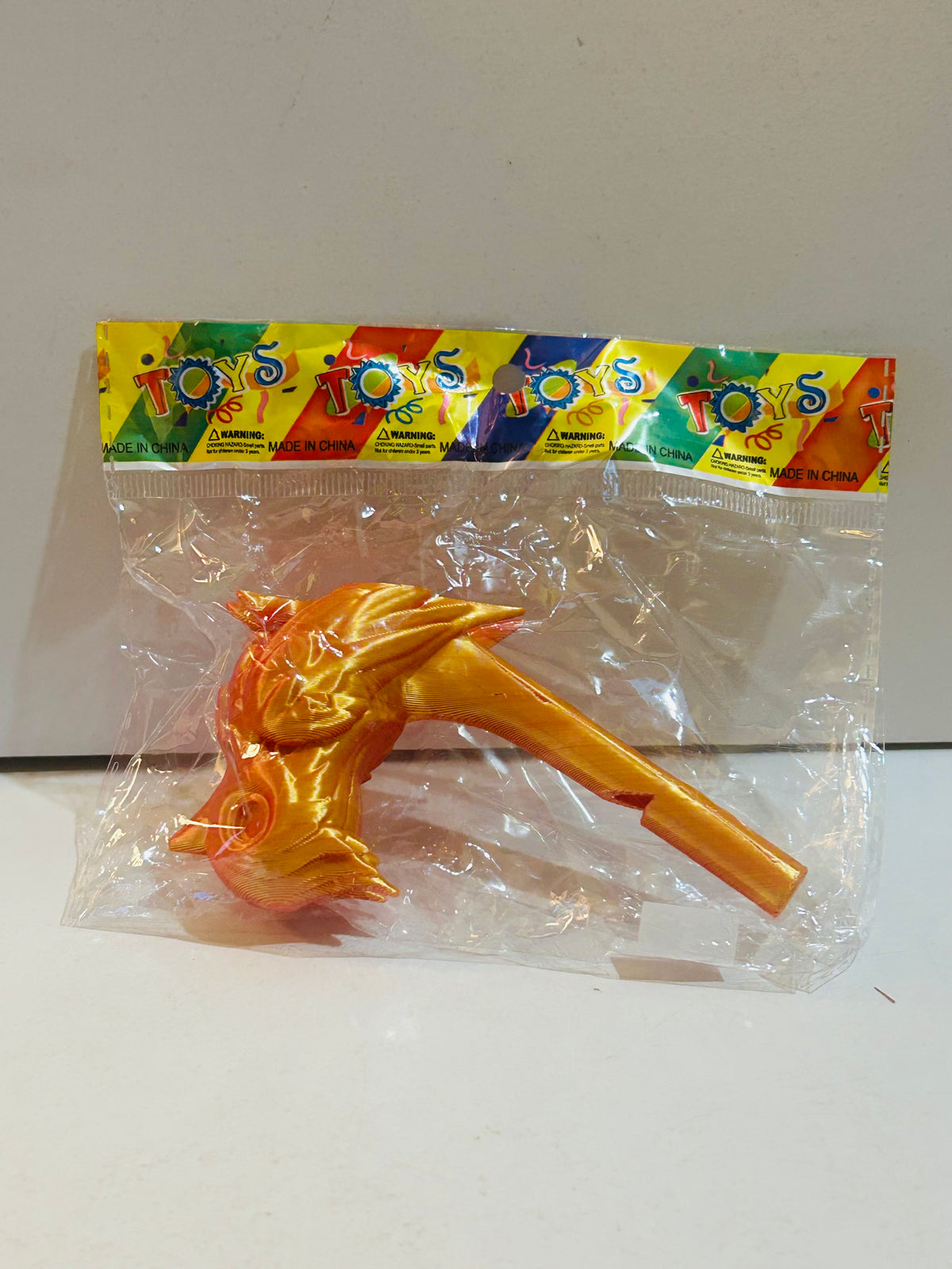 Gold and orange metallic plastic dragon figure on handle wand with wings and spikes, factory sealed in polybag with colorful TOYS header card