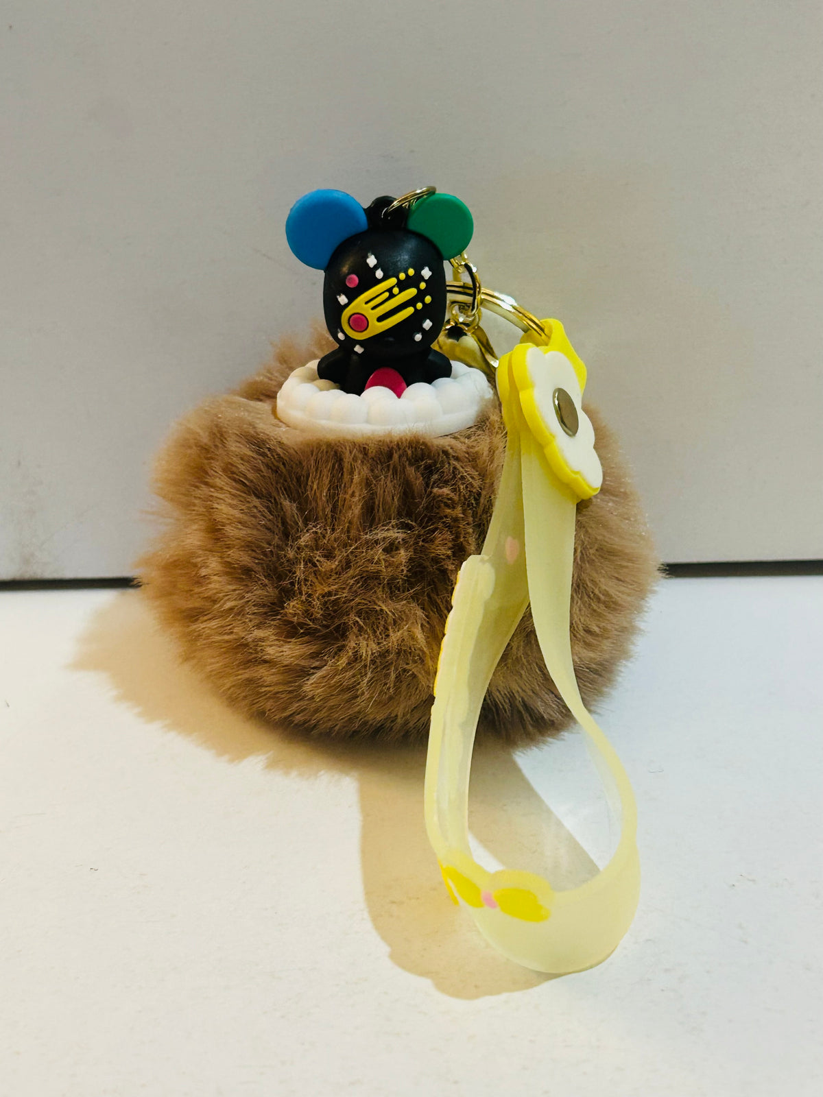 Brown plush pom pom keychain with black bear character figure topper and yellow Sweet Heart rubber lanyard strap with daisy charm