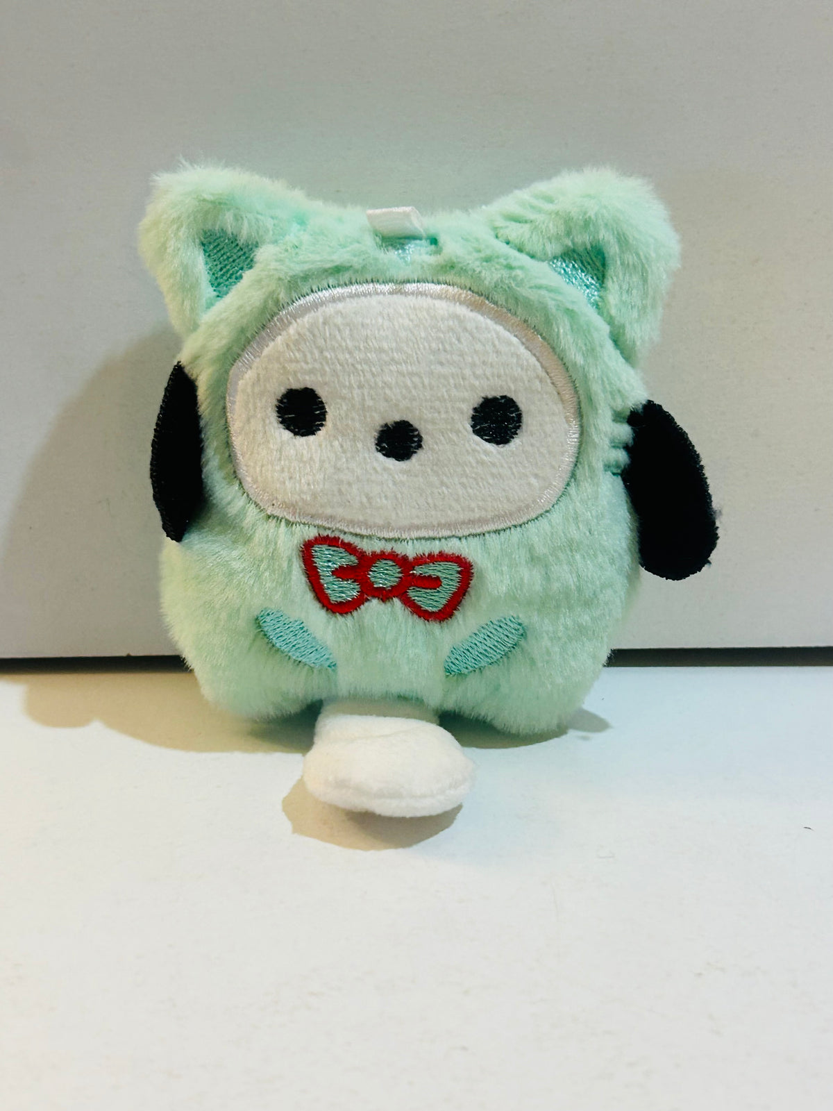 Pochacco Sanrio mint green costume plush soft toy with red bow tie and black floppy ears, approximately 3 inches