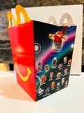McDonald's Happy Meal box with space-themed character artwork, red smile panel, and yellow handles