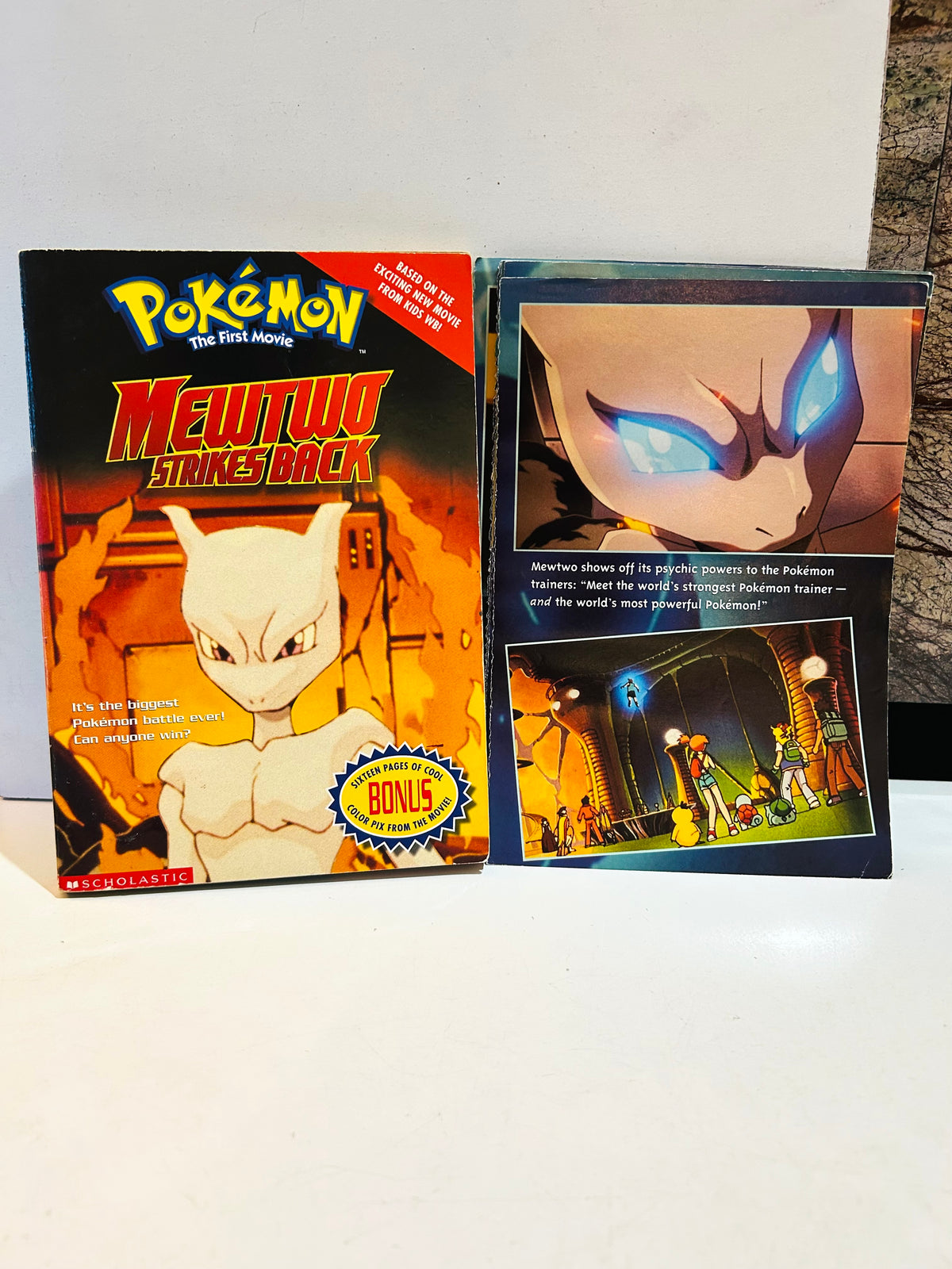 Pokémon Mewtwo Strikes Back paperback alongside detached color movie pages included with the book