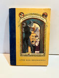 The Bad Beginning by Lemony Snicket paperback with yellow cover and dark blue spine panel