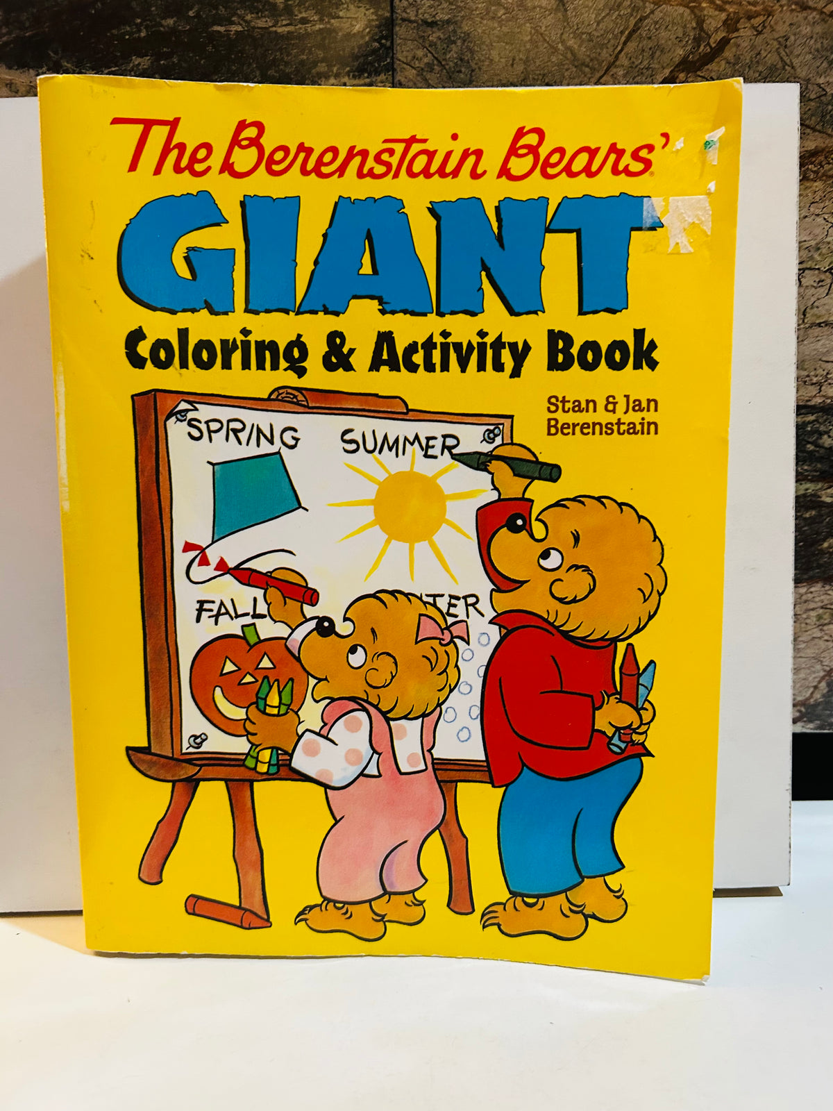 The Berenstain Bears Giant Coloring and Activity Book cover featuring Brother Bear and Sister Bear drawing Spring Summer Fall Winter seasons on an easel, bright yellow cover, by Stan and Jan Berenstain