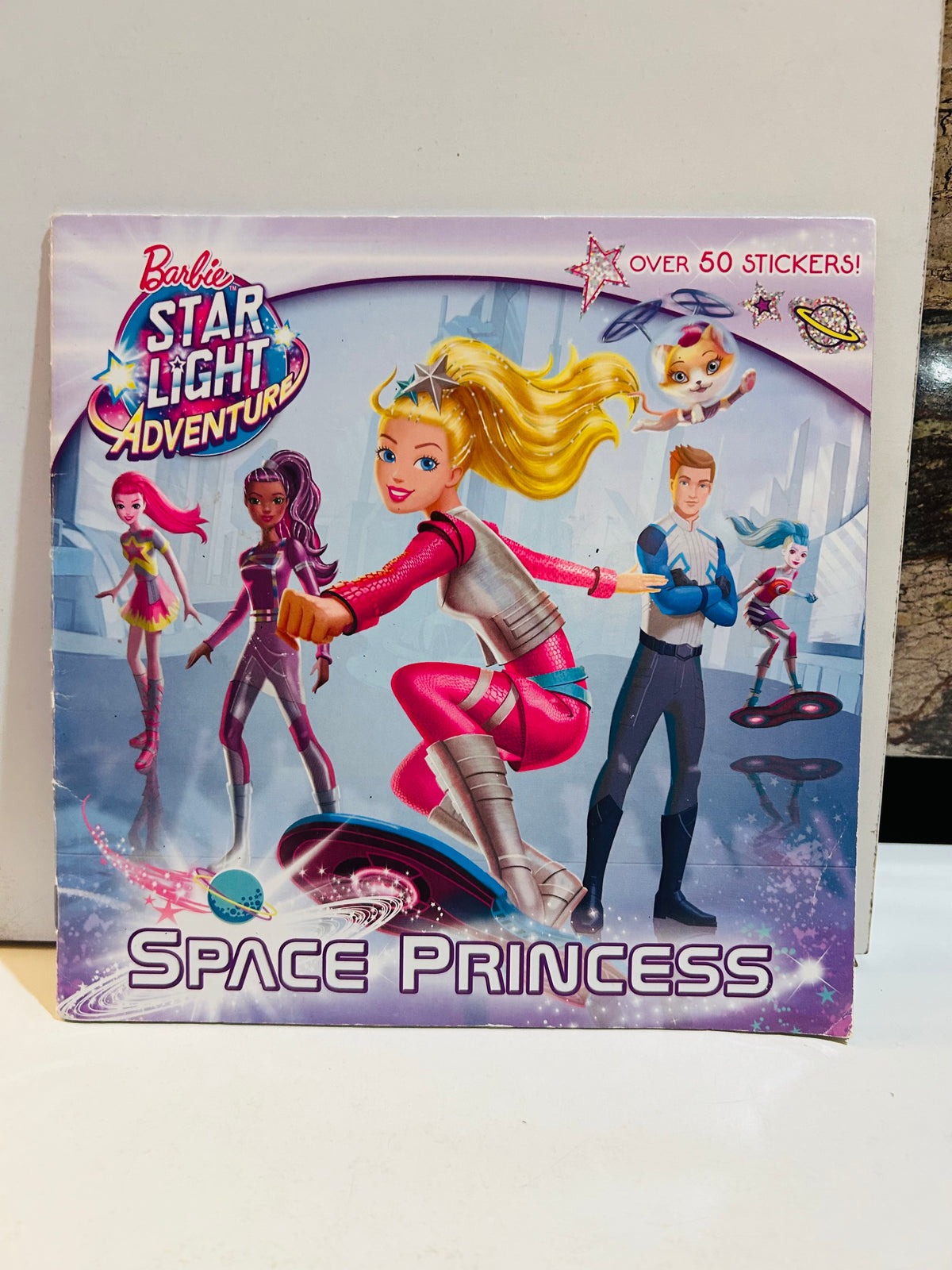 Barbie Star Light Adventure Space Princess 8x8 paperback book cover featuring Barbie in pink space suit on hoverboard with friends and flying cat, Over 50 Stickers callout, 2016