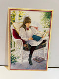 1996 American Girl Samantha collectible postcard featuring painted illustration of Samantha in white puffed-sleeve dress with red bow sitting on white wicker settee on sunlit porch reading a blue book
