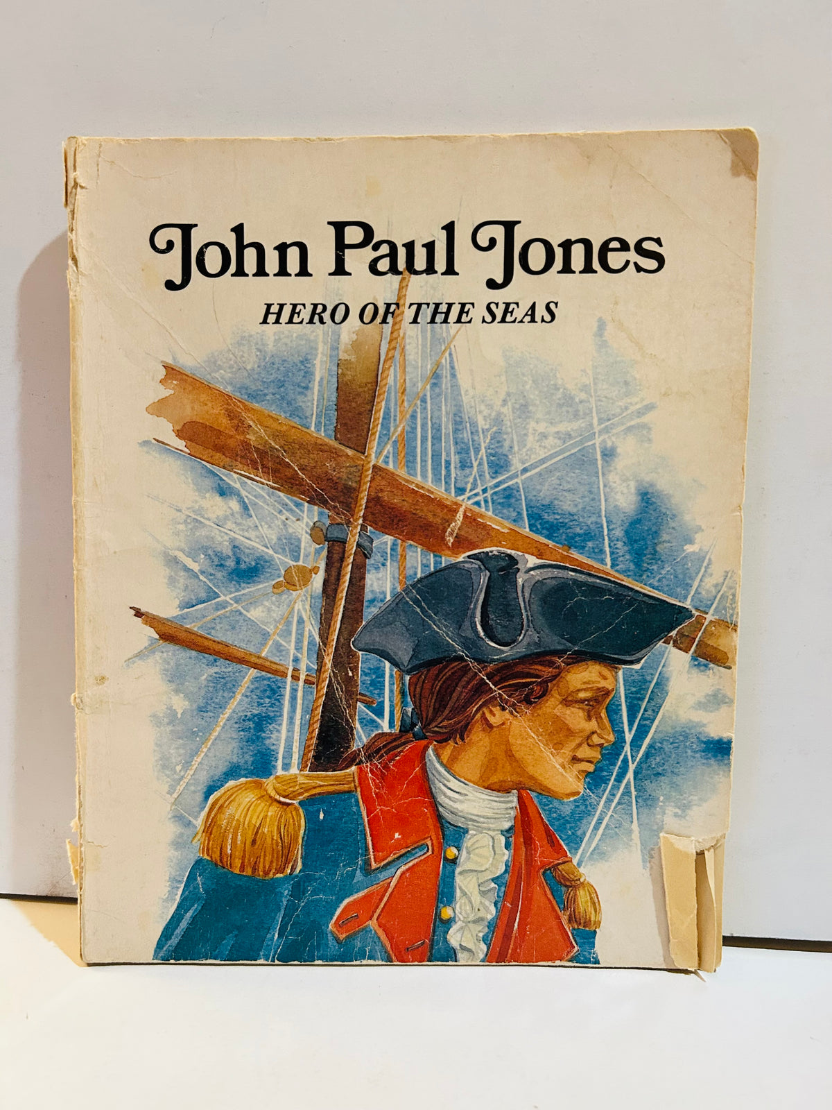 John Paul Jones Hero of the Seas vintage 1983 paperback book cover featuring illustrated portrait of John Paul Jones in blue naval uniform and tricorn hat with sailing ship rigging in background