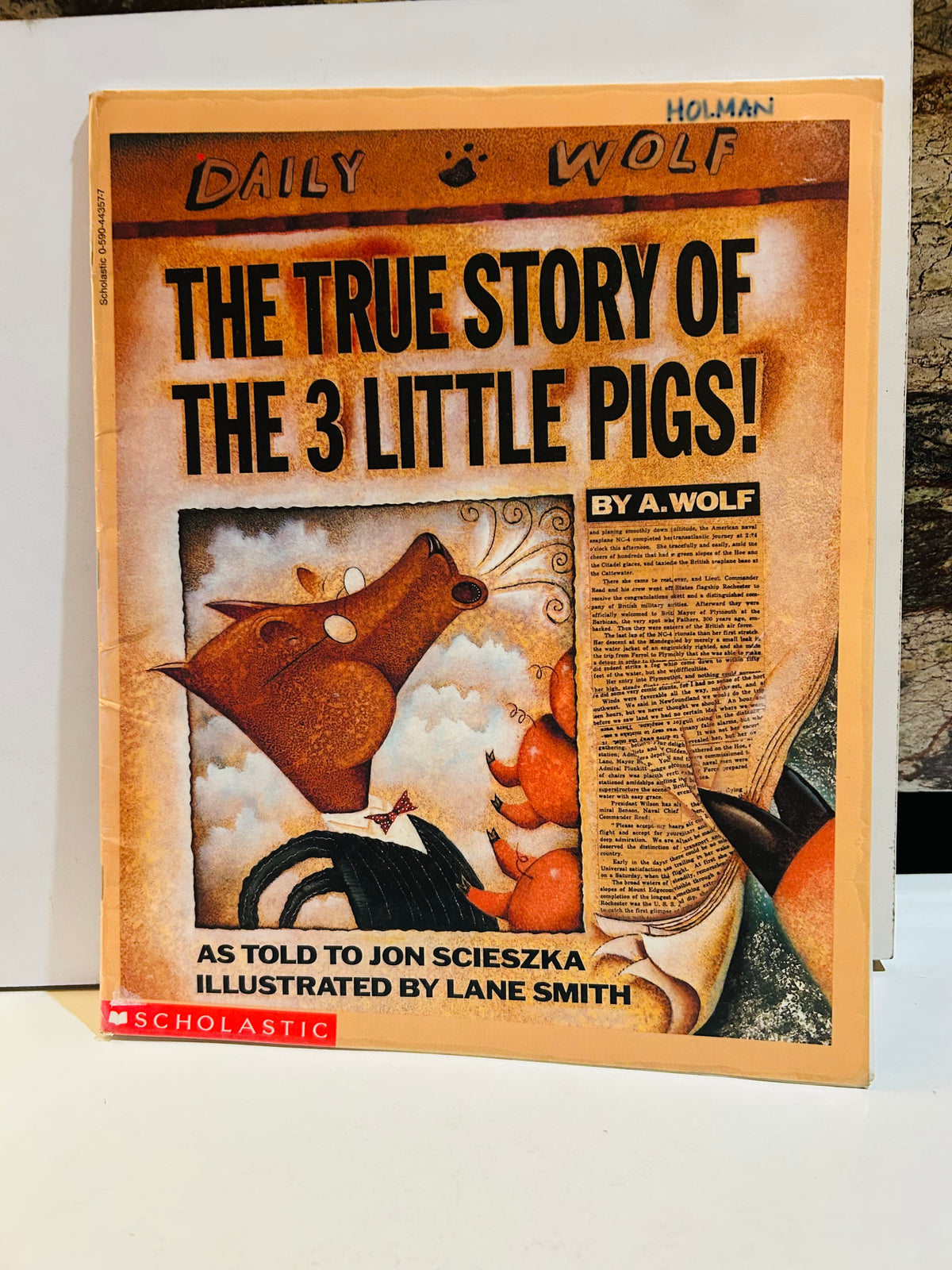 The True Story of the 3 Little Pigs paperback cover designed as Daily Wolf newspaper front page, written by A. Wolf as told to Jon Scieszka, illustrated by Lane Smith, Scholastic 1991, previous owner name written on top corner