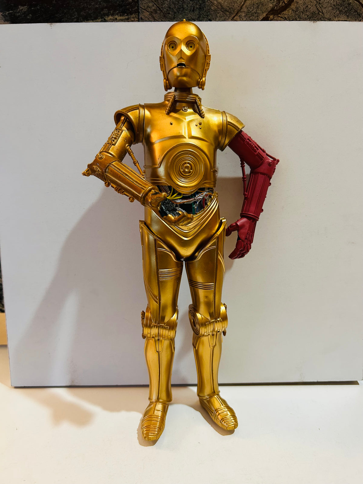 Star Wars C-3PO 10 inch action figure with signature red left arm from The Force Awakens Episode VII standing upright showing full gold metallic finish with detailed articulated joints and exposed wiring at midsection