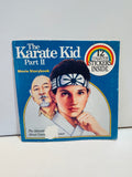The Karate Kid Part II Movie Storybook 1986 6x6 paperback cover featuring illustrated portraits of Daniel LaRusso in karate headband and Mr. Miyagi on blue background, 12 Collector Stickers Inside rainbow badge, The Adventure About Courage and Honor tagline