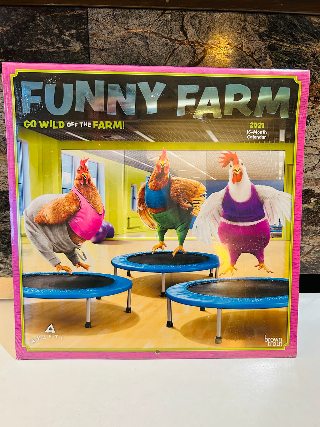 Funny Farm Go Wild Off the Farm 2021 16-Month Wall Calendar front cover featuring three chickens in workout clothes bouncing on mini trampolines, BrownTrout Avanti, sealed in shrink wrap