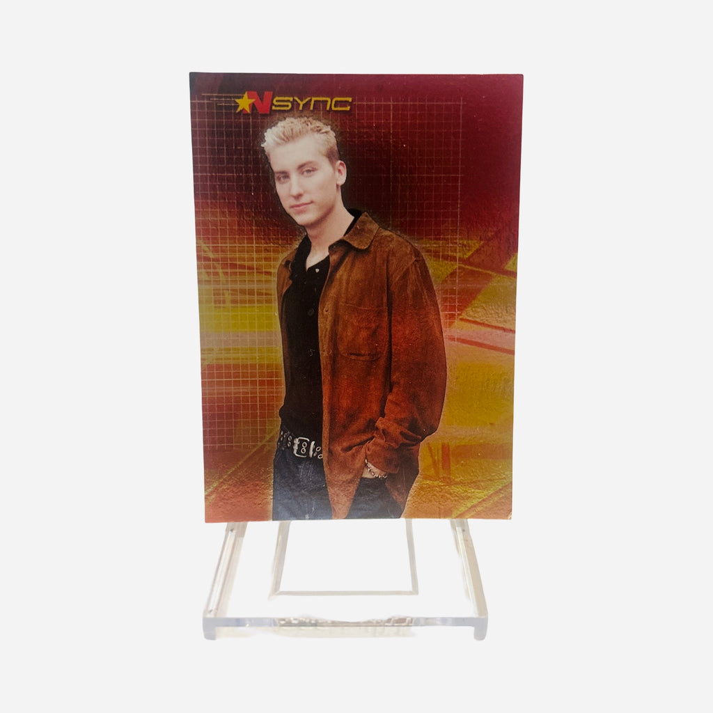 NSYNC Trading Card #28 Front – Lance Bass Frosted Spiky Tips Rust Brown Suede Jacket Black Tee Pendant Necklace Hands In Pockets Red Gold Grid Background 2000 Topps Winterland
