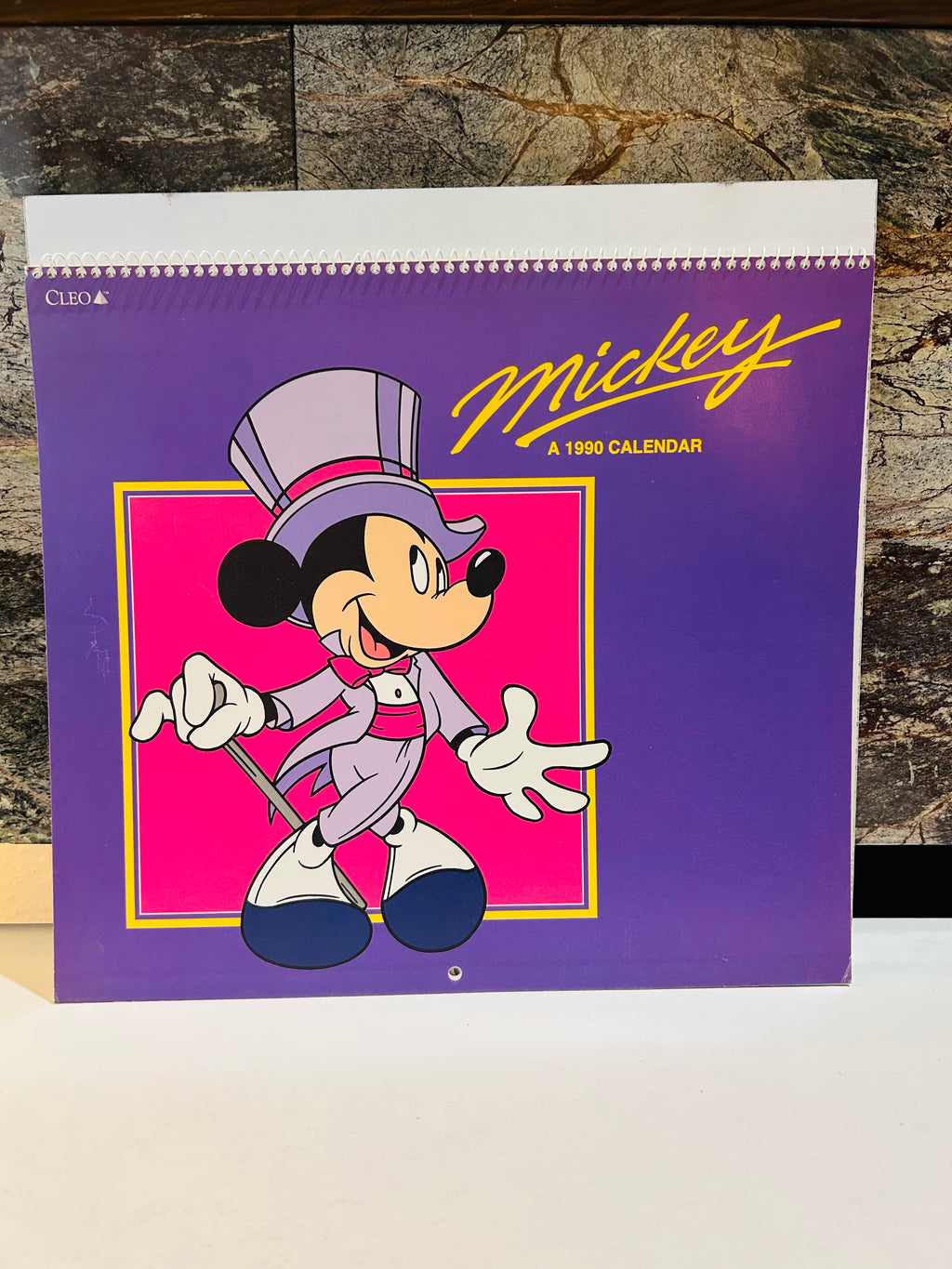 Mickey A 1990 Calendar front cover – purple background with Mickey Mouse in top hat and tuxedo, published by CLEO