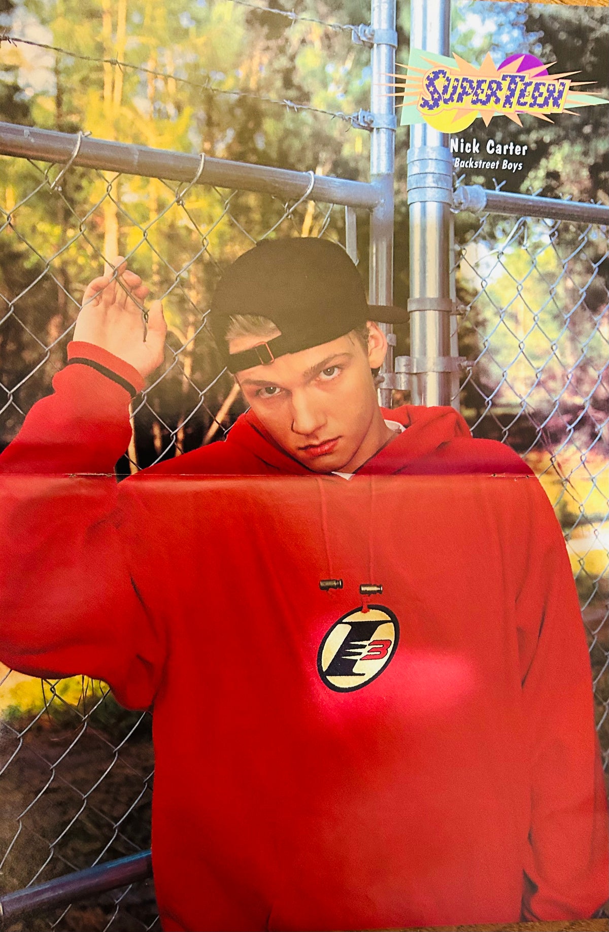 Nick Carter Backstreet Boys SuperTeen poster – solo portrait in red hoodie by chain-link fence