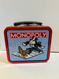 Preowned red Monopoly metal mini lunchbox tin with visible wear