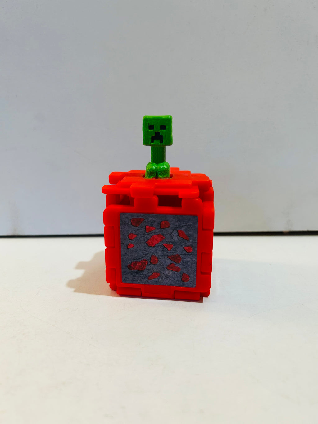 Red Minecraft Movie fold-out puzzle cube open with green Creeper figure