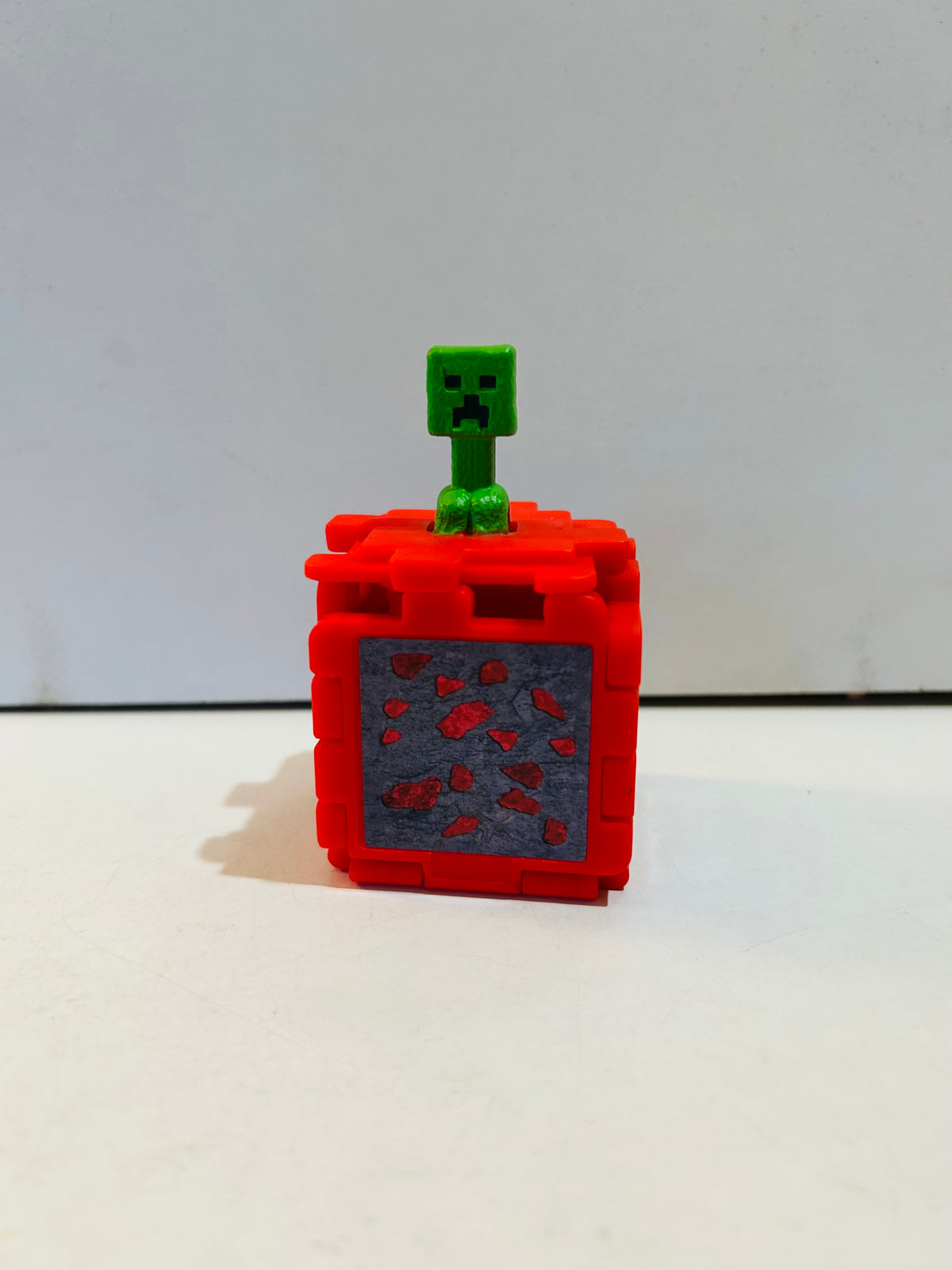 Red Minecraft Movie fold-out puzzle cube open with green Creeper figure