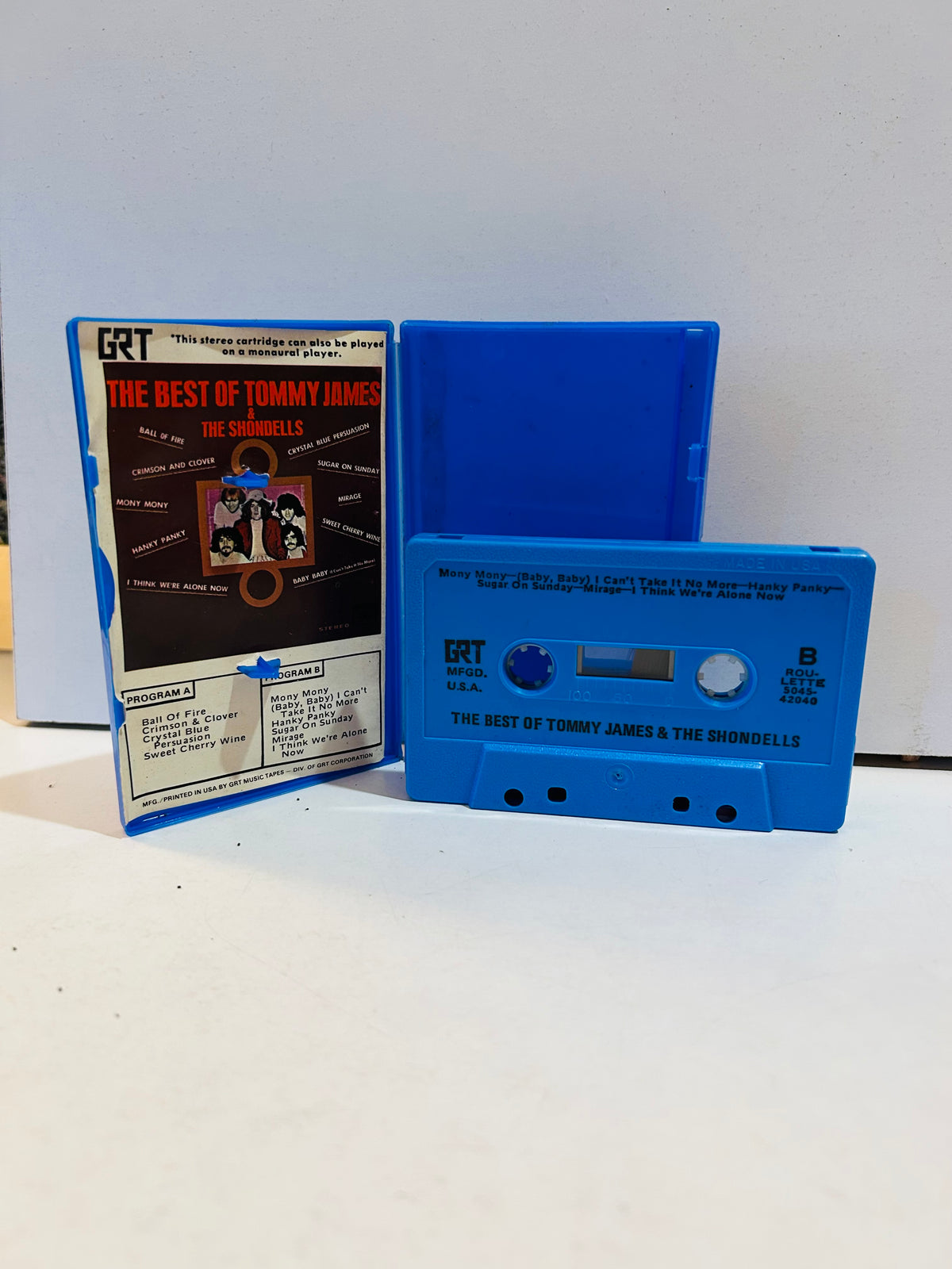 Blue GRT The Best of Tommy James and The Shondells cassette beside its open blue case and printed insert