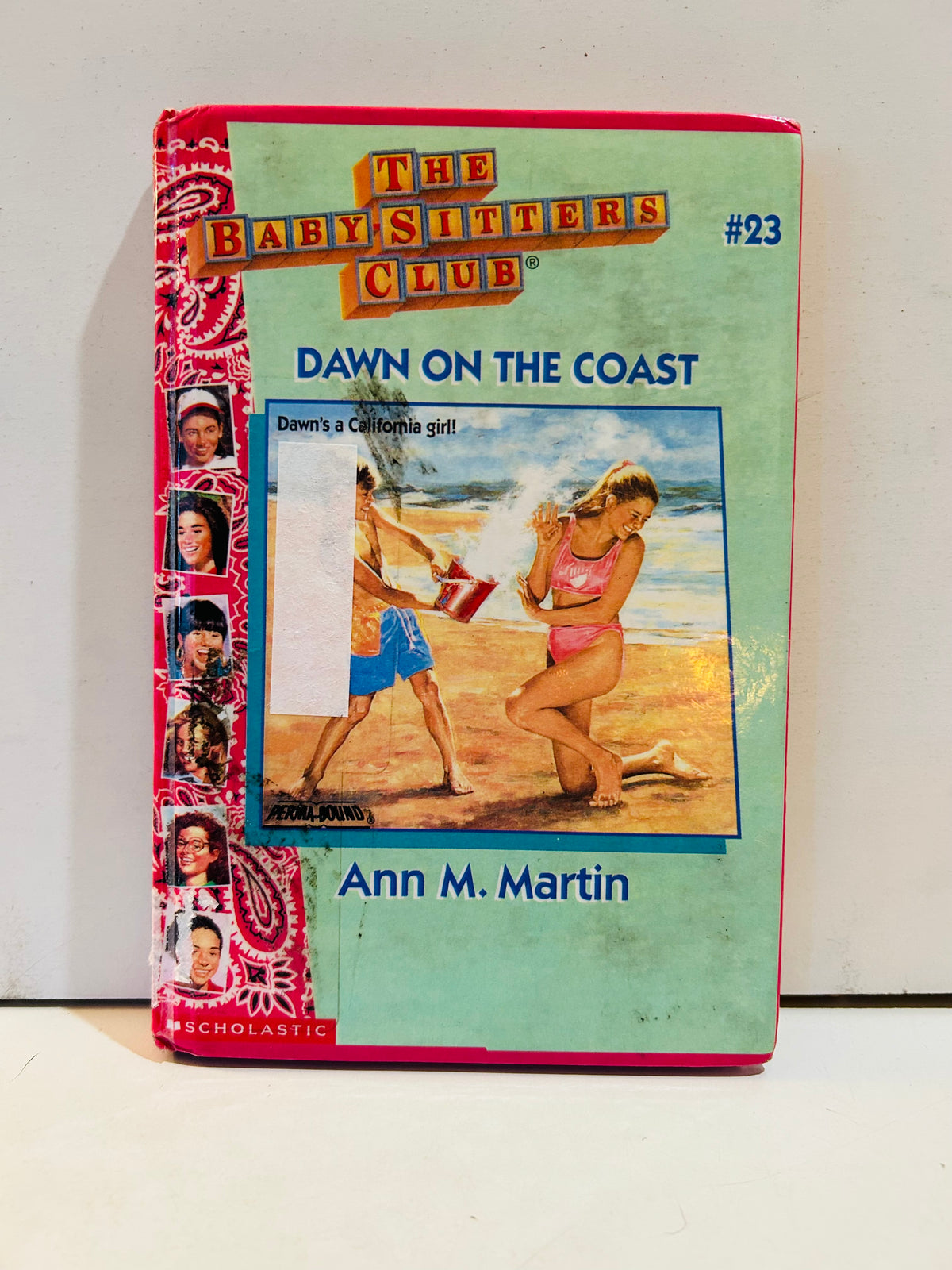 Ex-library hardcover of The Baby-Sitters Club number 23 Dawn on the Coast by Ann M. Martin with visible cover wear