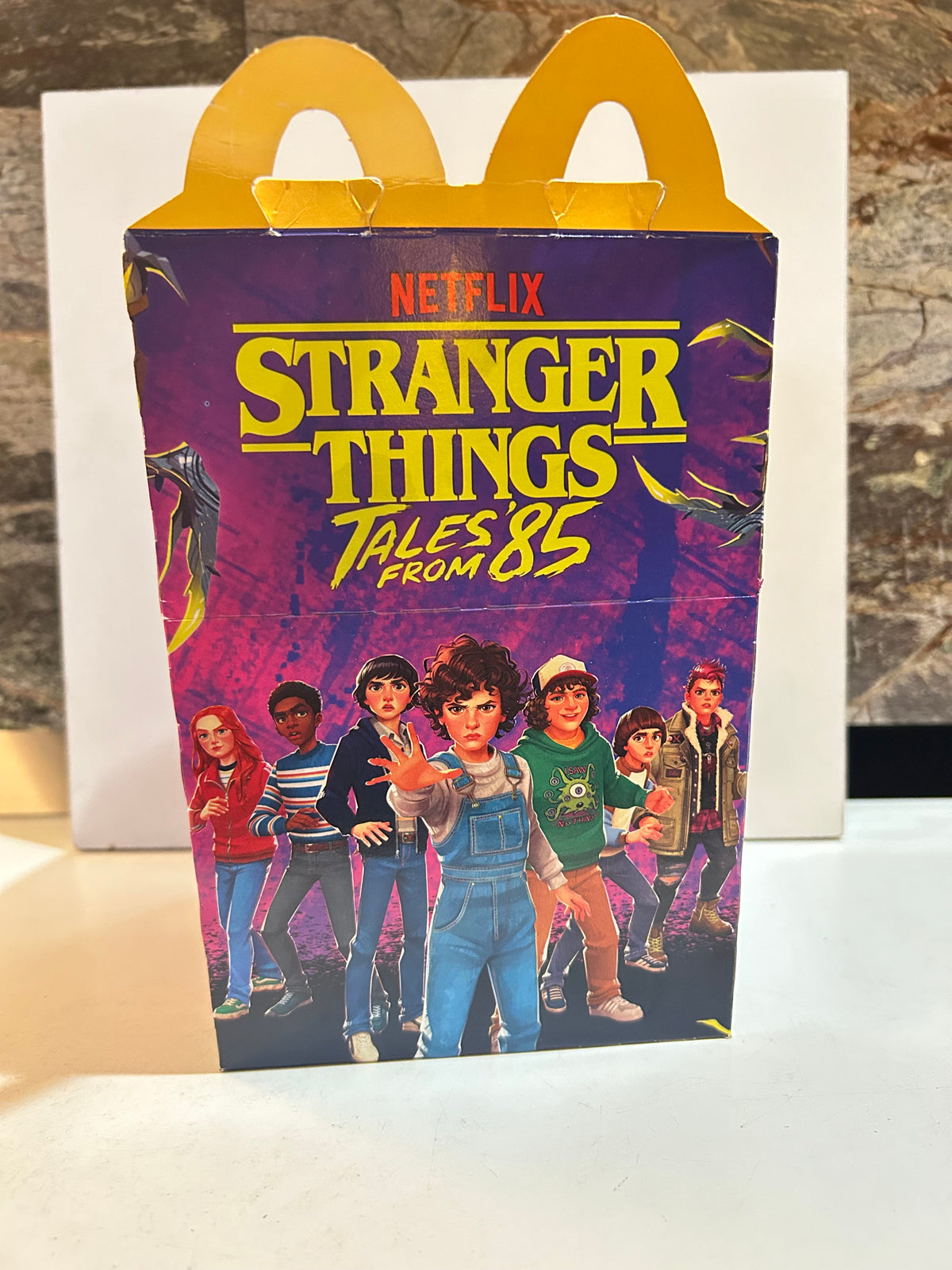 Preowned McDonald's Happy Meal box with Netflix Stranger Things Tales from '85 artwork and yellow arch handles