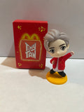 TinyTAN figure with silver-colored hair and red jacket on a yellow base beside its red McDonald's TinyTAN box