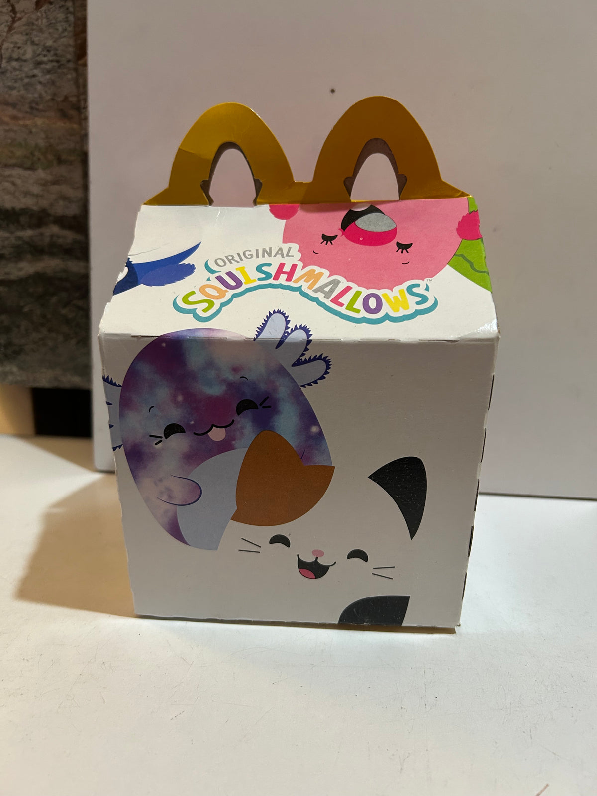 Preowned McDonald's Original Squishmallows Happy Meal box with colorful character artwork and yellow arch handles