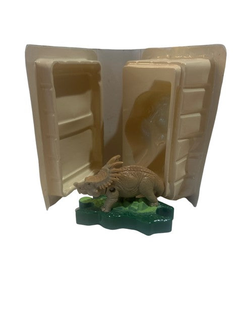 Ceratopsian dinosaur PVC figure on green base in open white clamshell case