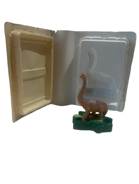 Dinosaur PVC figure on green base in open white clamshell case