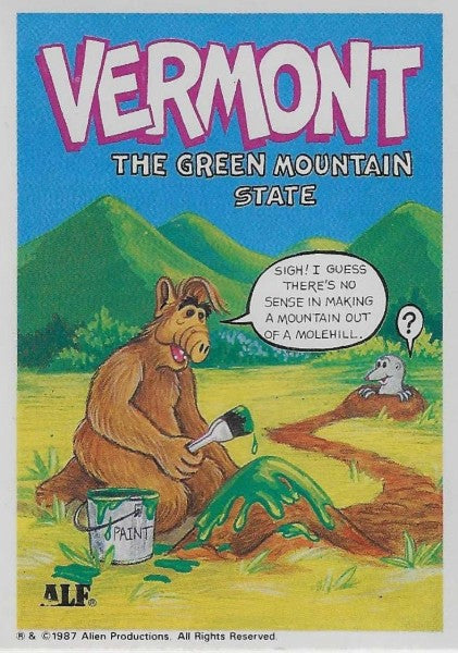 U.S. of ALF Vermont sticker featuring ALF with green paint bucket painting a molehill green while confused mole pops out with question mark and real Green Mountains in background